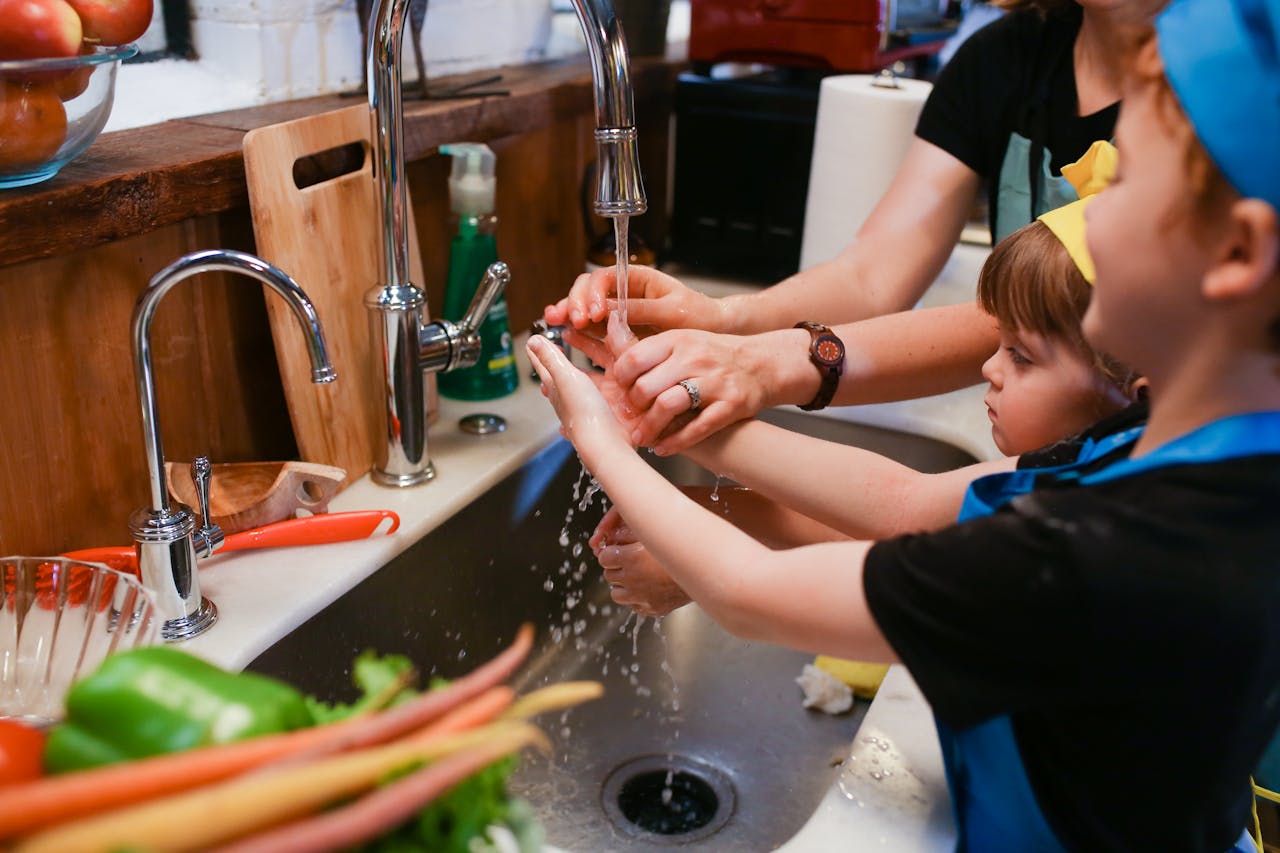 award-img A family cooking activity emphasizing hygiene with kids washing hands in the kitchen.